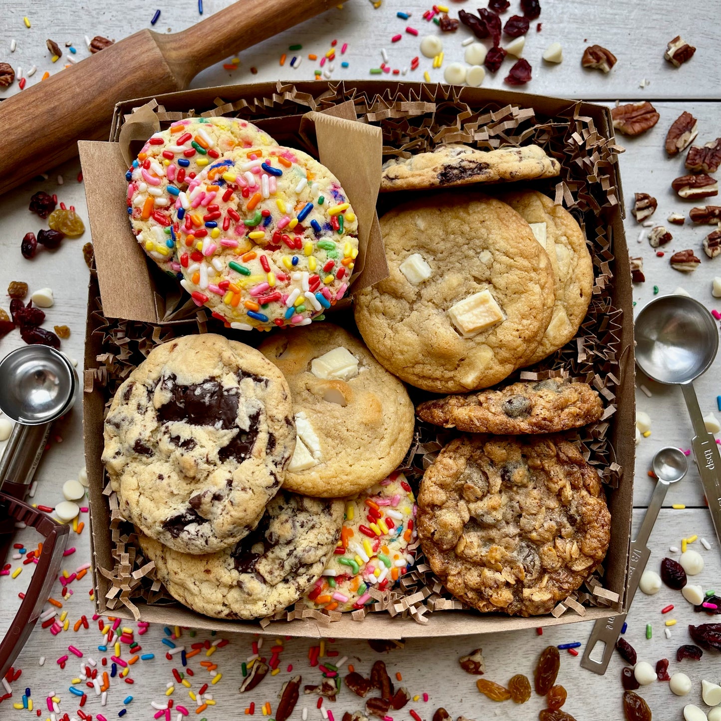 Assorted gift box with sprinkle cookies, chocolate chip cookies, white chocolate macadamia cookies, and oatmeal raisin cookies.