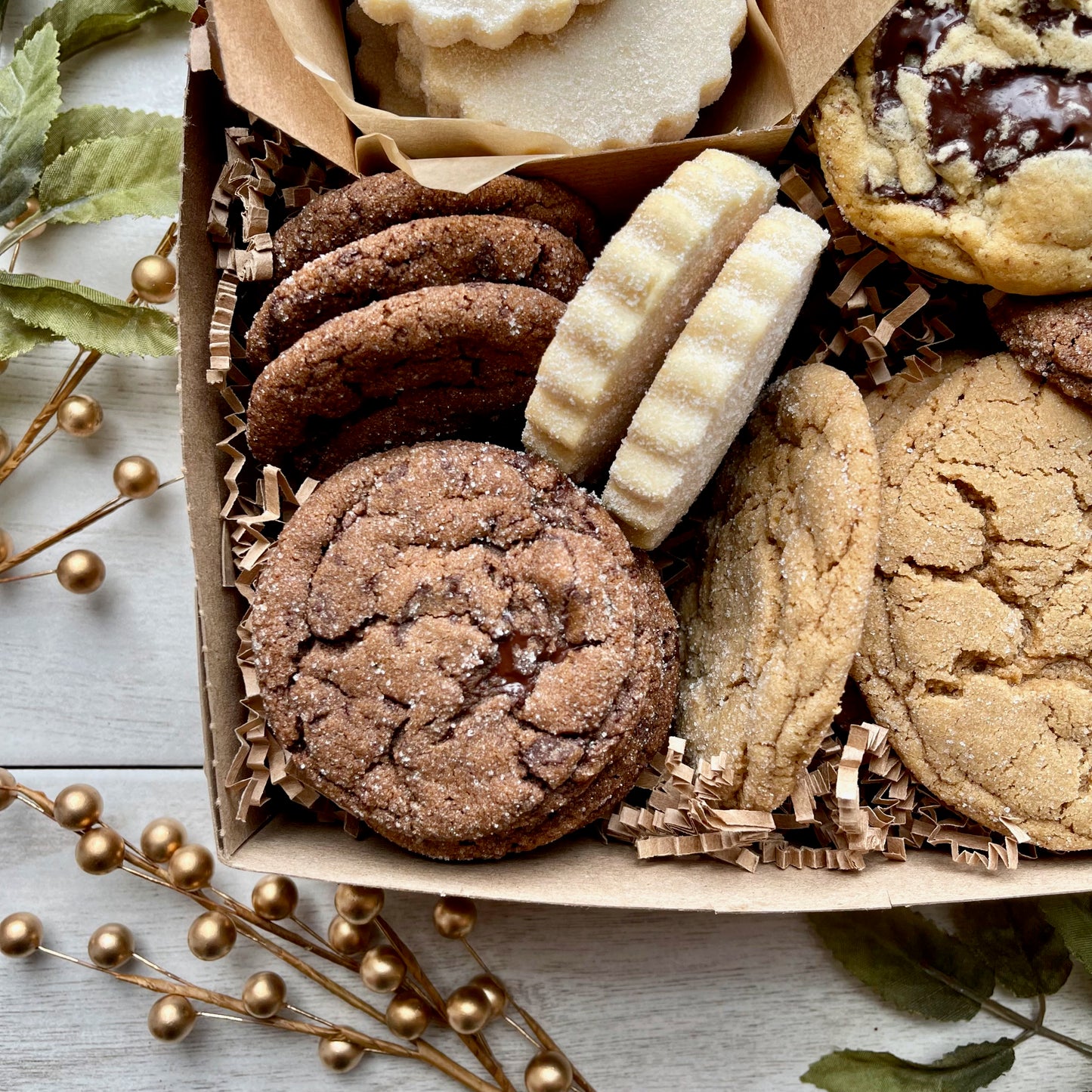 Holiday cookie gift box with chocolate ginger cookies, vanilla shortbread, brown sugar cookies, and chocolate chunk cookies.