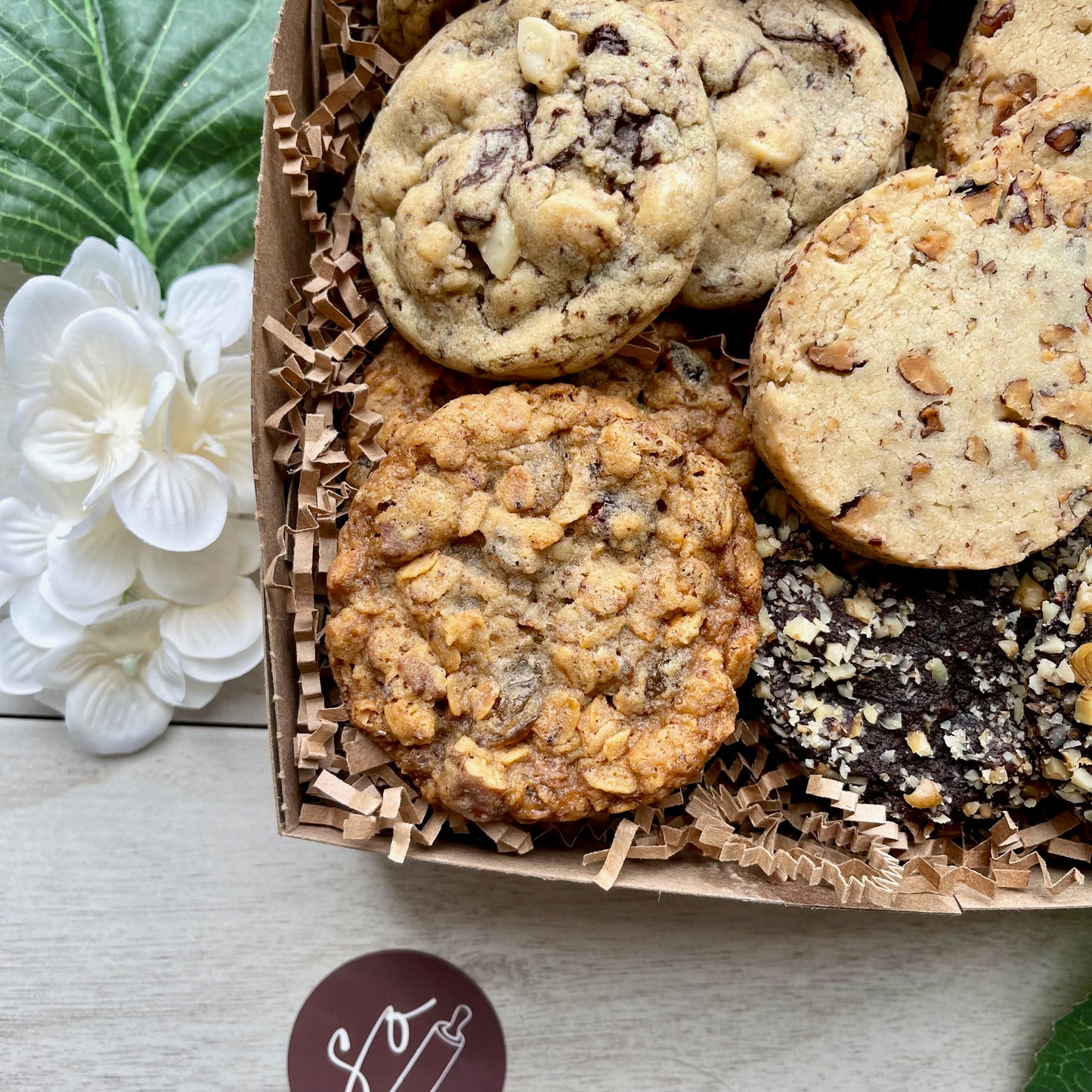 Assorted cookie gift box with maple pecan shortbread, double chocolate macadamia cookies, oatmeal raisin pecan cookies, and chocolate walnut cherry cookies.