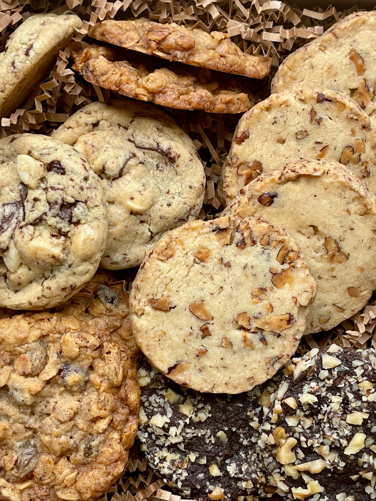 Assorted cookie gift box with maple pecan shortbread, double chocolate macadamia cookies, oatmeal raisin pecan cookies, and chocolate walnut cherry cookies.