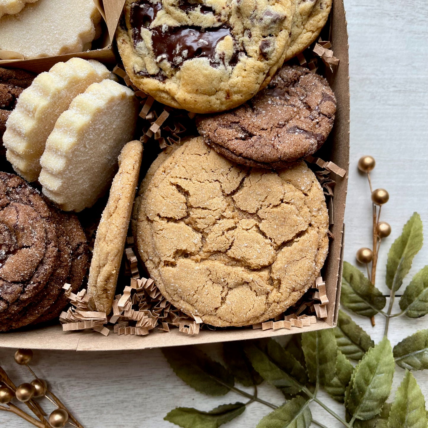 Holiday cookie gift box with chocolate ginger cookies, vanilla shortbread, brown sugar cookies, and chocolate chunk cookies.