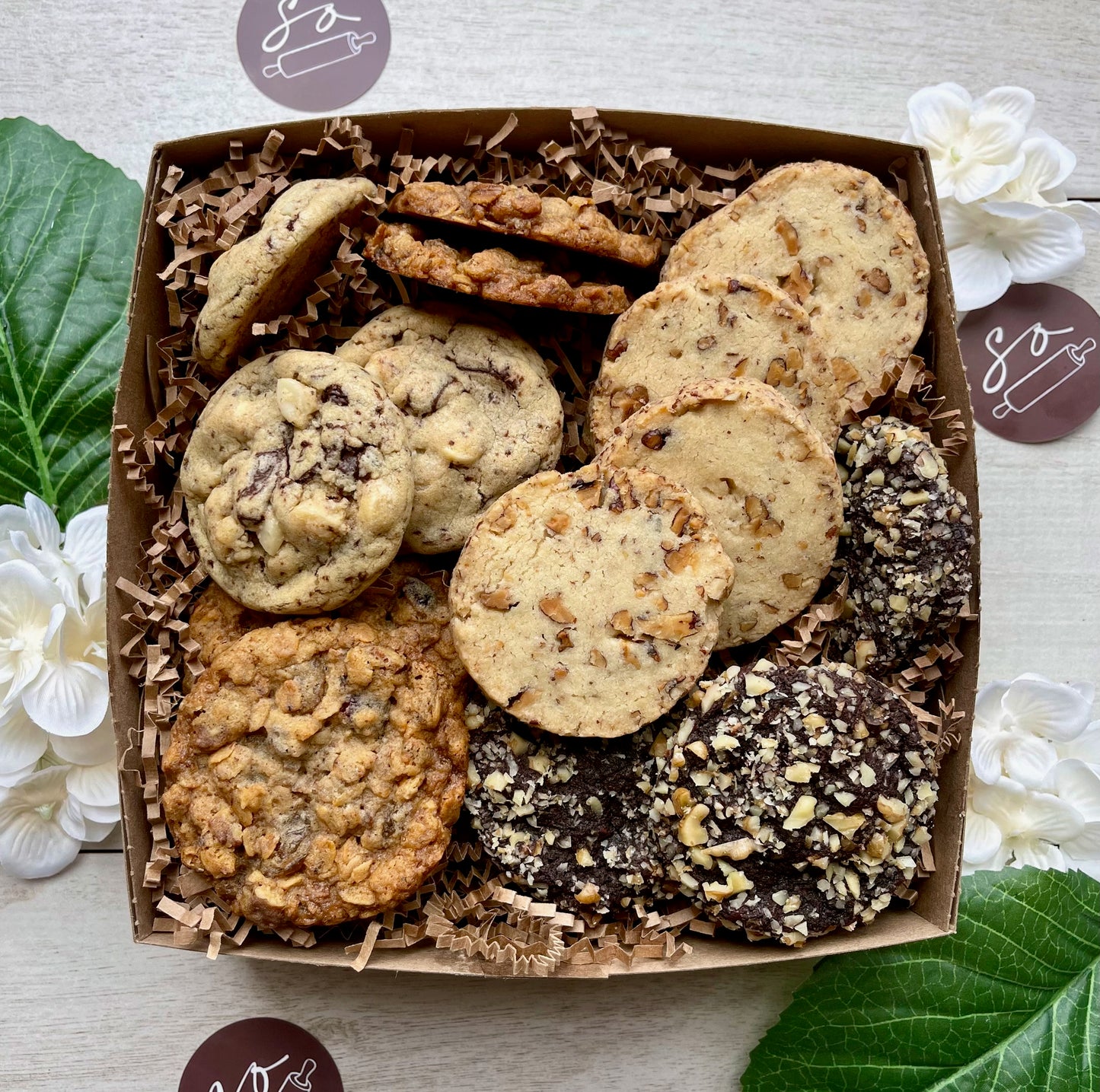 Assorted cookie gift box with maple pecan shortbread, double chocolate macadamia cookies, oatmeal raisin pecan cookies, and chocolate walnut cherry cookies.